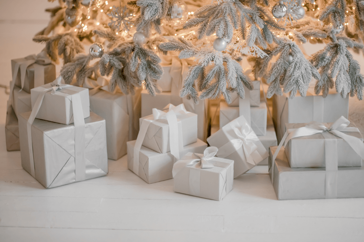Aesthetic Christmas gifts for women 40+ wrapped in elegant white paper under a decorated Christmas tree